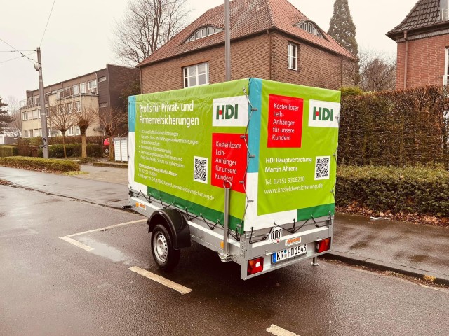 Ein Anhänger mit Werbung der Agentur, der auf der Straße steht