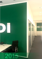 Foto von Innenräumen der HDI Agentur Glombitza 2015. Zu sehen sind ein langer Gang, eine grüne Wand mit einem Teil des HDI Logos und ein Schreibtisch mit Schreibtischstuhl.	