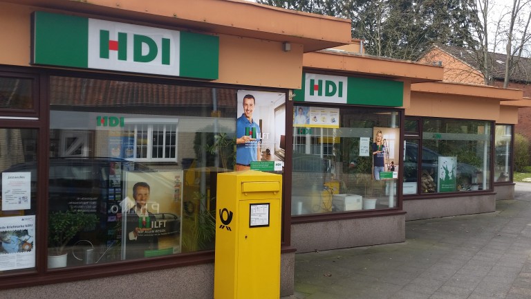 Blick auf die Agentur von außen, die Front ist verglast und man sieht HDI Werbung