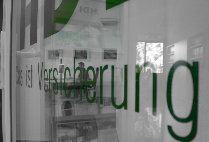 Schriftzug "Das ist Versicherung" an Glastür