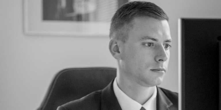 Schwarz-weiß-Foto eines Mitarbeiters am PC bei der Arbeit