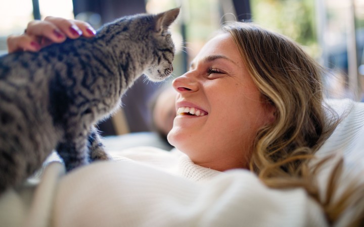 Lächelnde Frau mit Katze auf dem Arm