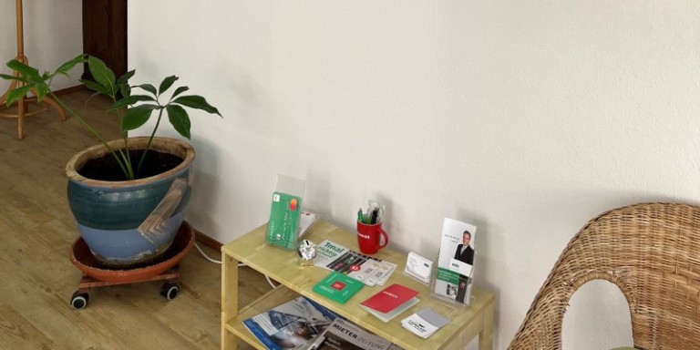 Man sieht einen Beistilltisch auf dem Prospekte und Infomaterial von HDI ausgelegt ist.