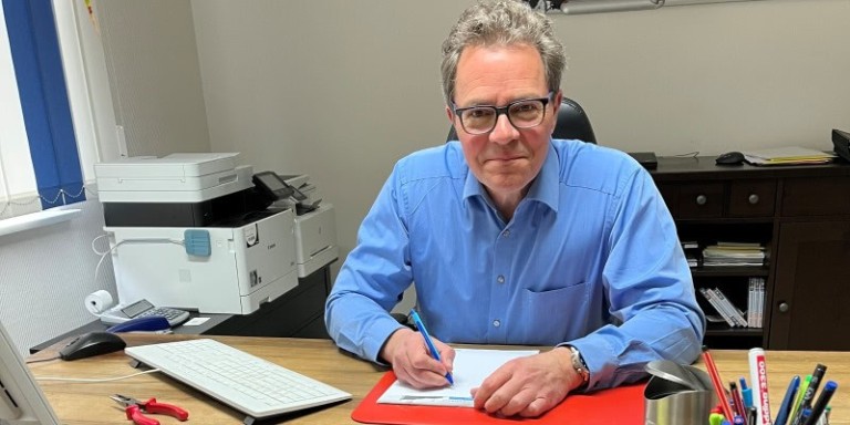 Carsten Backeler sitzt am Schreibtsich und arbeitet