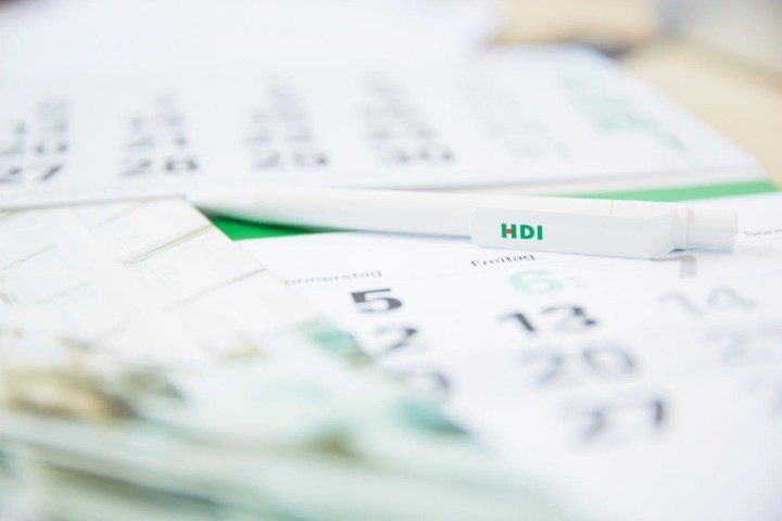 Ein weißer HDI Stift liegt auf einem Kalender