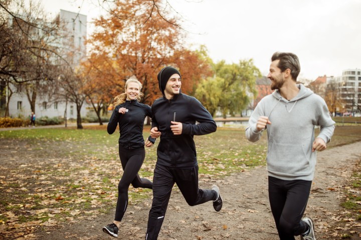 Drei Personen die lächelnd gemeinsam Joggen gehen
