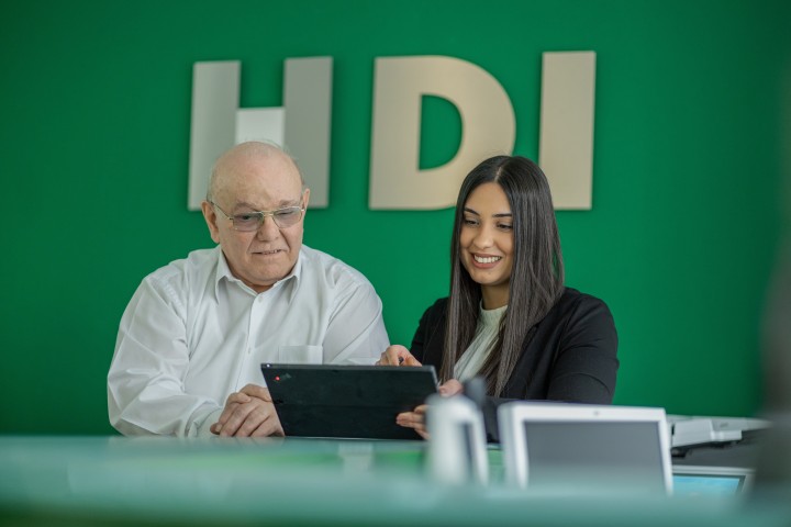 Eine Mitarbeiterin zeigt einem Mitarbeiter etwas auf einem Ipad.