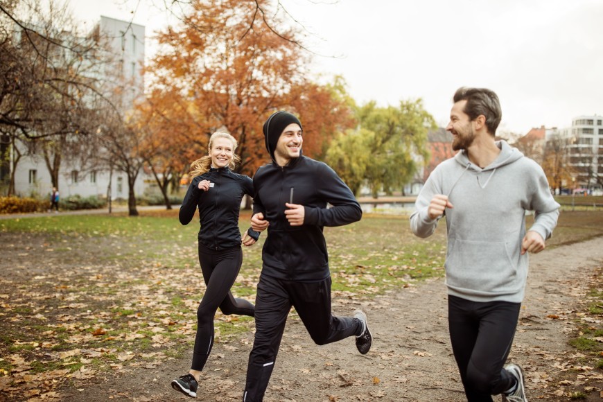 Drei Personen die lächelnd gemeinsam Joggen gehen