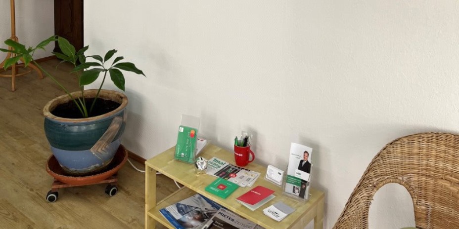 Man sieht einen Beistilltisch auf dem Prospekte und Infomaterial von HDI ausgelegt ist.