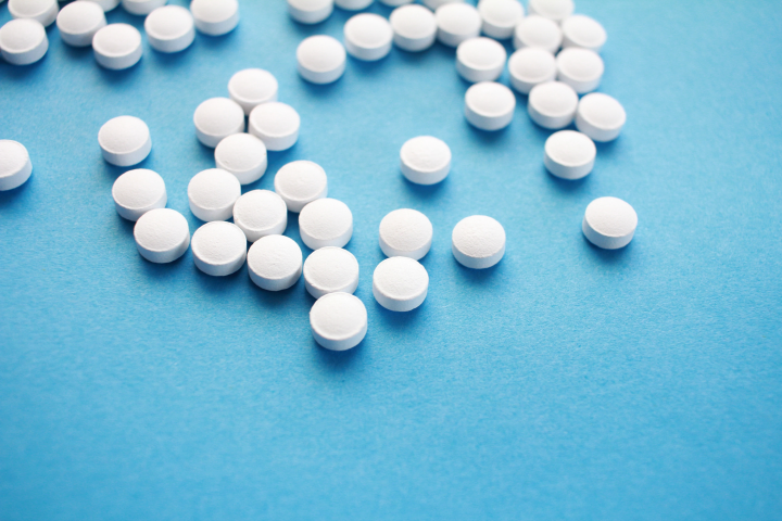 Weiße Tabletten auf blauem Untergrund
