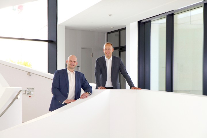 Michael Gleitz und Mitarbeiter auf weißer Treppe