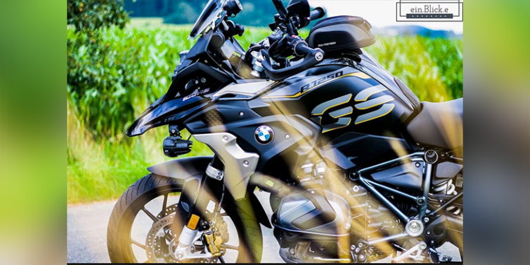 BMW Motorrad steht auf einer grauen Straße und dahinter ist ein grünes Feld