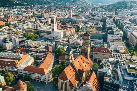 Luftaufnahme der Stadt Stuttgart mit Blick auf Dächer, Kirchen und städtische Bebauung.