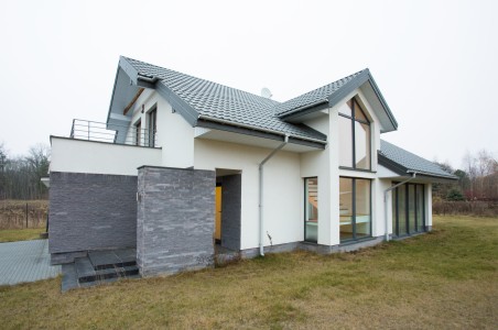 Modernes Einfamilienhaus, freistehend, mit grauer Garage und eiem großen Treppenausfgang in der Mitte aus Glas
