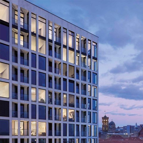 Aufnahme einer Glasfront eines Hochhauses im Abendlicht