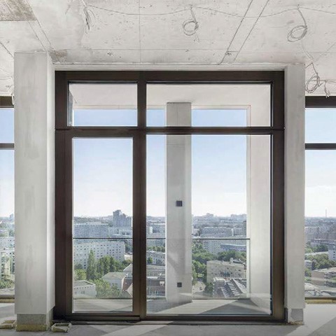 Blick auf eine Großstadt aus der Fensterfront einer großen modernen Penthouse-Wohnung im Rohbauzstand