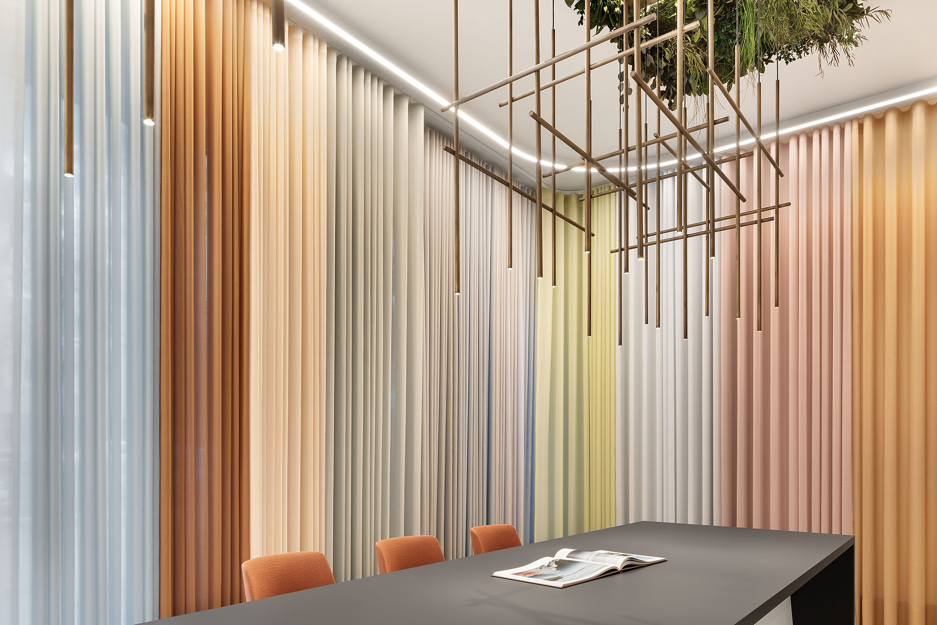 Modernes Büro mit einer kunstvollen goldenen Lampe an der Decke und Raffstores in brauen und beigefarbenen Naturtönen