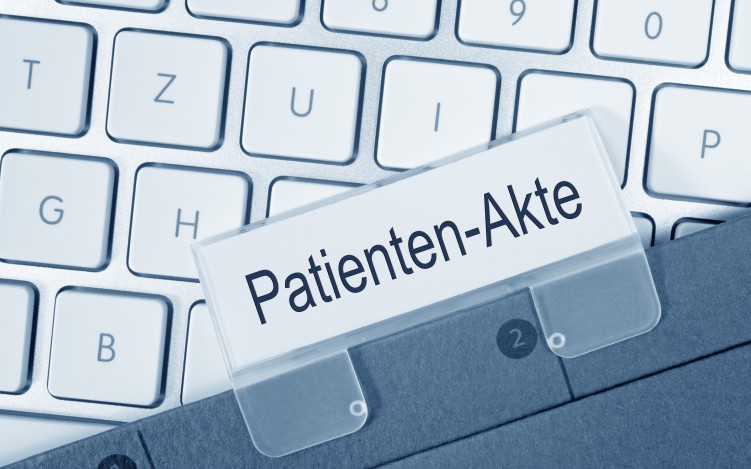 weiße Tastatur und darauf eine Akte mit einem Schild Patientenakte