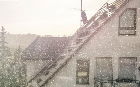 Blick auf den Giebel eines Hauses während Schneetreiben