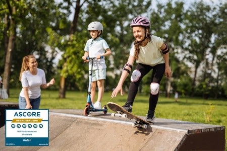 Glückliche Jugendliche auf einer Halfpipe, während die Mutter daneben steht und auch lacht