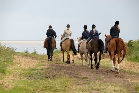 Reiter mit Helm am Strand
