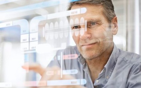 Mann tippt konzentriert auf einem digitalen Bildschirm