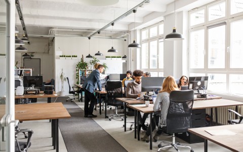 Männer und Frauen arbeiten in offener Bürofläche