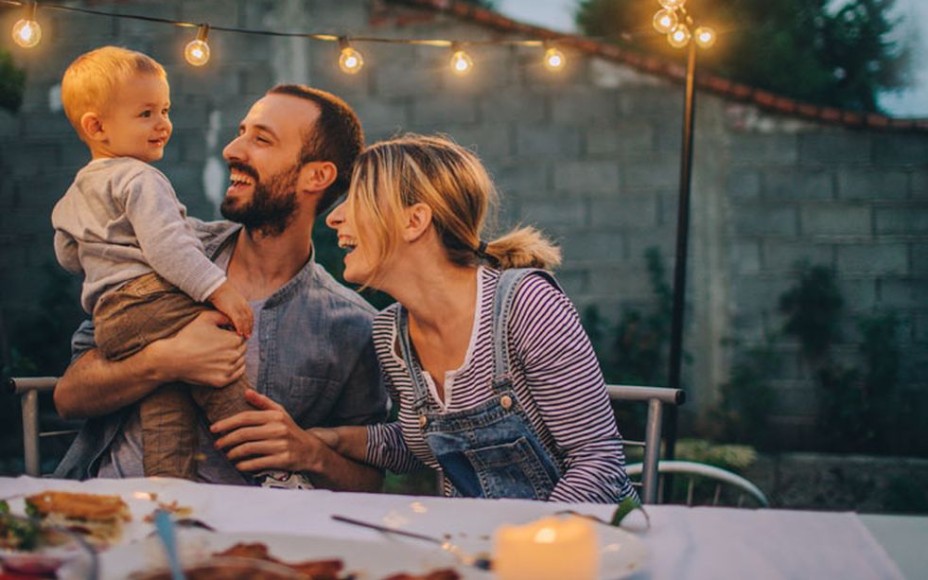 Eltern mit jungem Sohn essen im Freien Abendessen