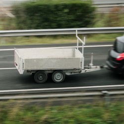 Anhänger an einem Auto fahrend auf der Straße