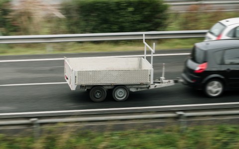 Anhänger an einem Auto fahrend auf der Straße