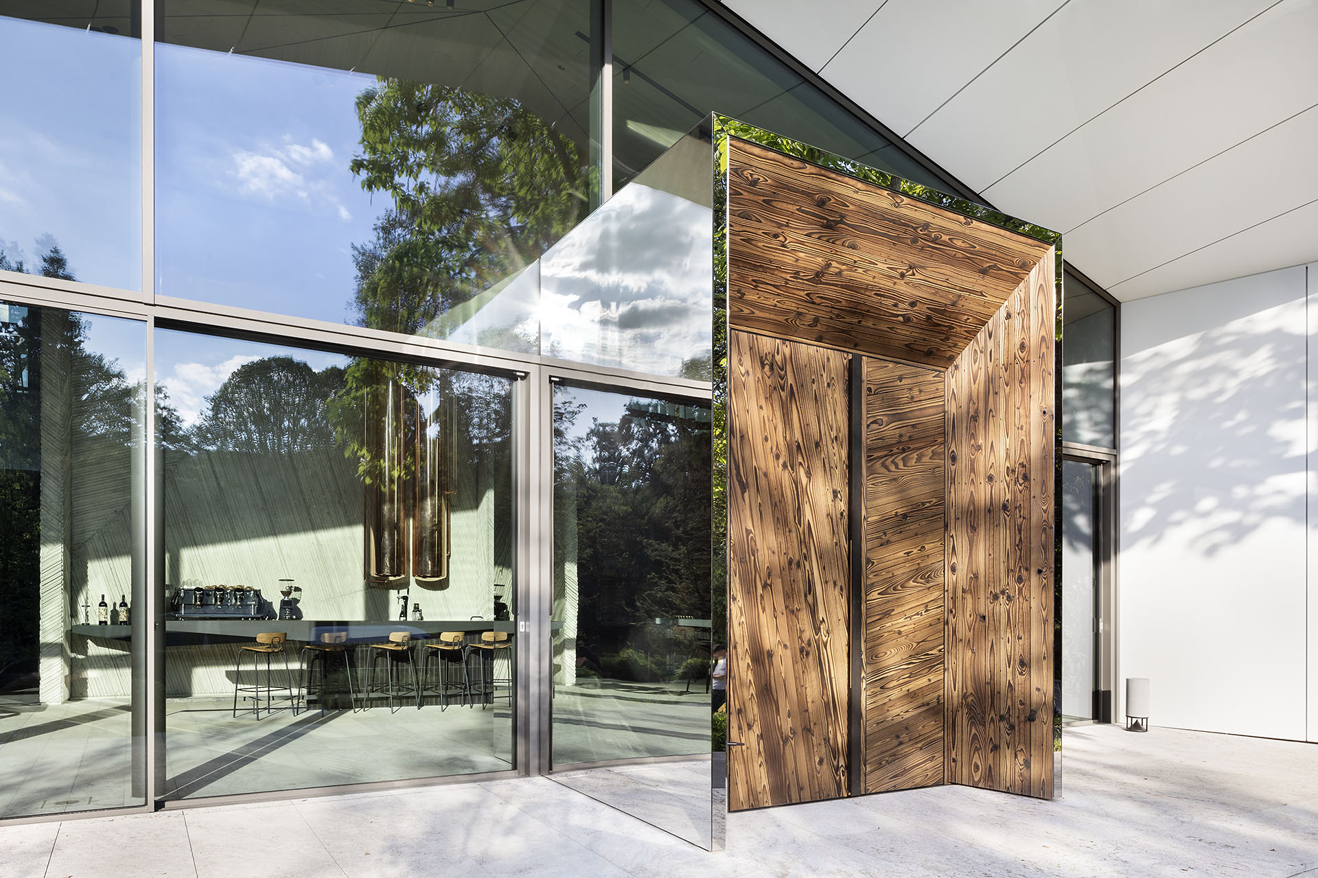 Große Fensterfront mit einer hoehn modernen Eingangstür aus Holz