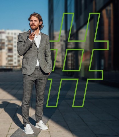 Ein Mann im Anzug steht draußen und schaut auf sein Smartphone. Im Hintergrund ist ein großes Hashtag-Symbol.