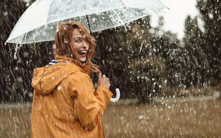 Frau im Regen mit Regenschirm