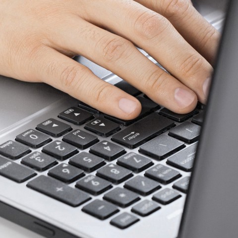 Hand am Laptop