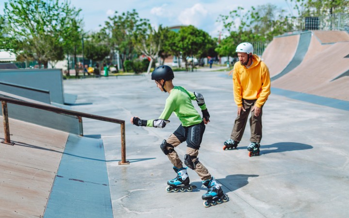 Vater und Sohn auf Inlineskates in der Halfpipe