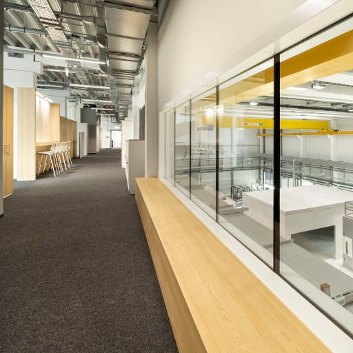 Große, weiße, leere und sehr moderne Produktionshalle mit gelben Stahlträgern und silbernen Lüftungsschächten