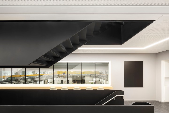 Konferenzraum in einem modernen Bürokomplex mit breiten schwarzen Treppen und weißen Wänden