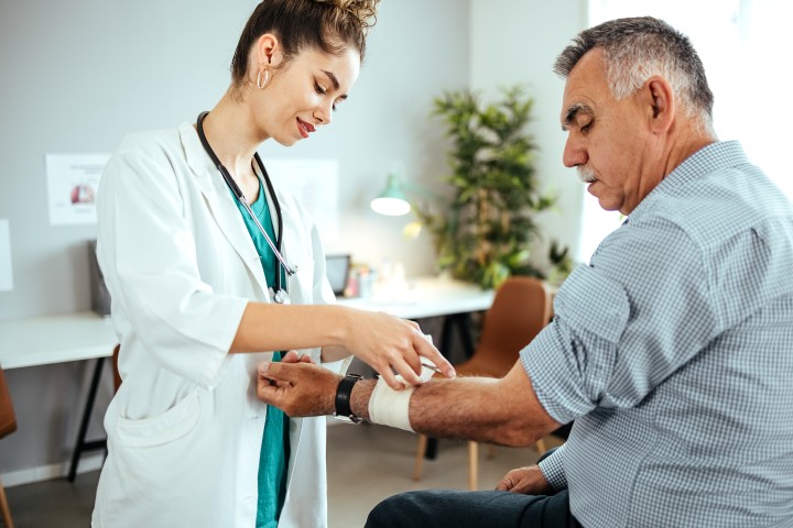 Frau mit weißem handtuch auf dem Kopf unterzieht sich einer Schönheitsbehandlung im Gesicht