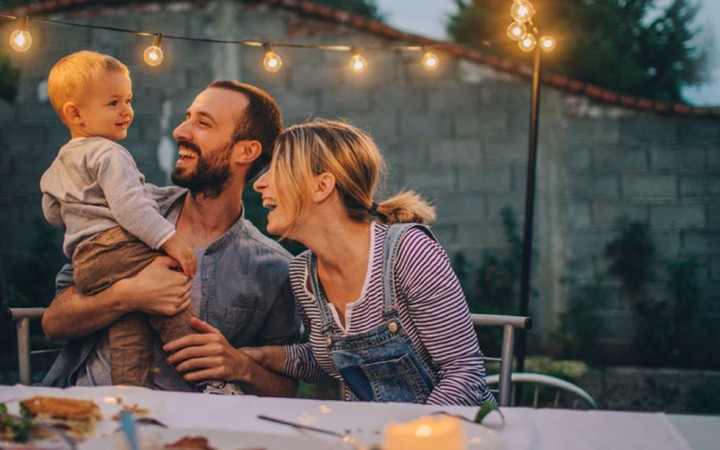 Eltern mit jungem Sohn essen im Freien Abendessen