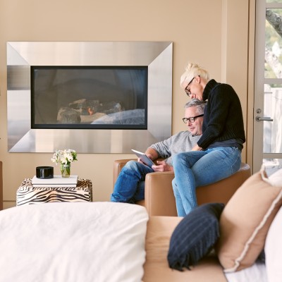 Familie mit zwei Kindern auf Rücken und Schultern geht lachend im  Wald bei Sonnenschein spazieren