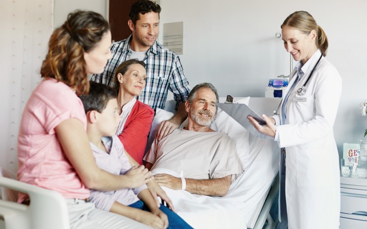 Ärztin berät Patienten mit seiner Familie