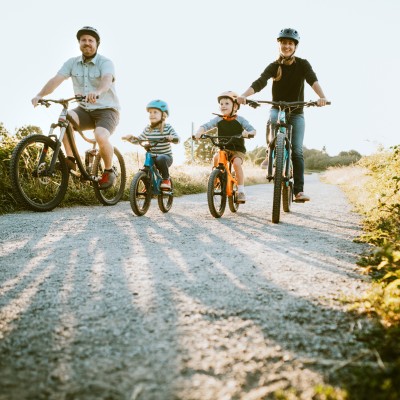 Familie mit zwei Kindern fährt in der Natur Fahrrad