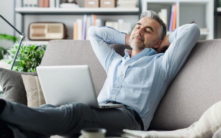 Mann sitzt entspannt auf der Couch