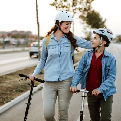 Mutter und Sohn schieben ihre E-Roller
