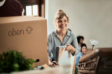 Frau mit Bilderrahmen in der Hand zieht um