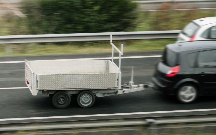 Anhänger an einem Auto fahrend auf der Straße