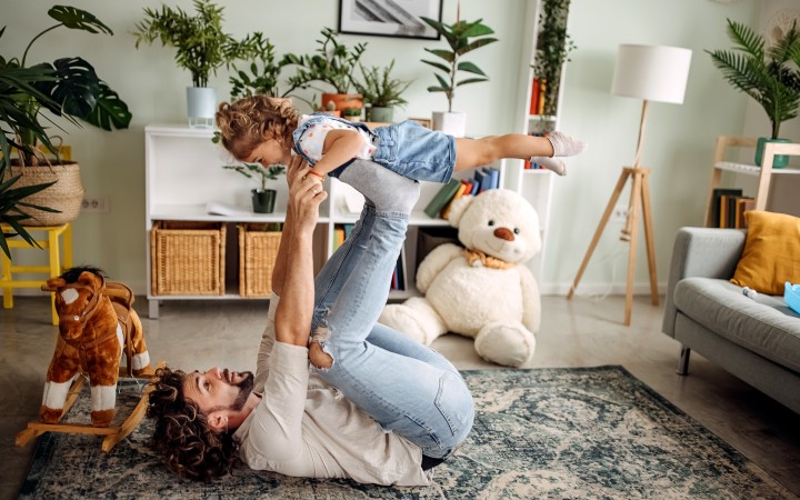 Vater und Sohn sitzen nebeneinander auf einem Sofa und schauen sich an