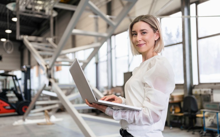 Frau mit Laptop in einer Halle